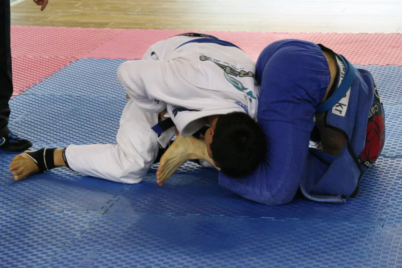 Dois competidores de kimono durante uma luta de jiu-jitsu brasileiro